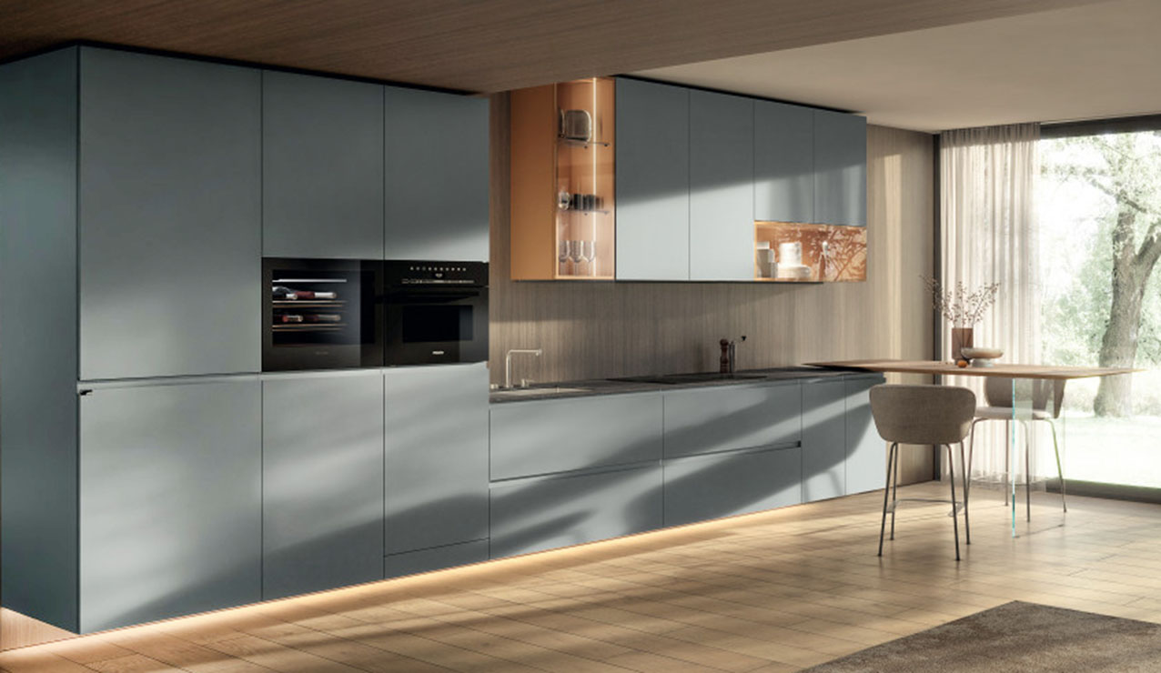 Si sviluppa lungo la parete la cucina 36e38 Cut di Lago che ha le ante lisce con apertura a gola disponibili in laccato opaco o in vetro colorato. Le basi sospese alleggeriscono la composizione; inoltre, l'integrazione perfetta di top, ante e fianchi sottili, realizzati nello stesso materiale, dà vita a una superficie uniforme e continua. Il bancone laterale ha il piano in appoggio sul top e il sostegno in vetro trasparente. Prezzo su richiesta. https://www.lago.it