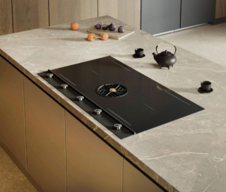 Largo 90 cm, il piano aspirante a induzione P904IHK2M30NT della Serie Professional di Bertazzoni permette di gestire le funzioni tramite manopole. Il pannello di controllo è in Carbonio, la superficie è in vetro nero lucido e le manopole hanno finitura Titanio. Le quattro zone Octa da 3 kW, con due configurazioni Multizone, offrono massima libertà in fase di cottura, adattandosi a diverse tipologie di preparazione. Il sistema di aspirazione raggiunge i 610 m³/h, assicurando un’estrazione efficace e silenziosa, mentre la classe energetica A++ garantisce un equilibrio ottimale tra consumi e performance. Prezzo in via di definizione. www.bertazzoni.com