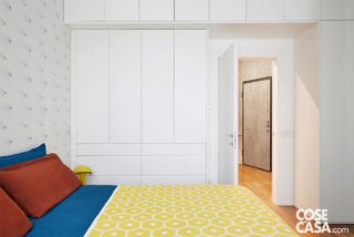 La camera da letto si apre direttamente sulla zona d'ingresso dell'abitazione. La forma irregolare dell'atrio non poteva essere modificata per la presenza di una parete perimetrale obliqua
derivata dalla precedente suddivisione dell'unità immobiliare unica originale Nonostante ciò è stato possibile ricavare un volume indipendente per il vestiaire, sfruttando la rientranza
di risulta tra la porta d'entrata e la camera matrimoniale.
Nella camera matrimoniale il letto sommier è di Materassi & Materassi con lenzuola in puro lino di Once Milano, plaid giallo Honey di Pappelina. Sul comodino Tronchetto di Cimento, la lampada da tavolo gialla è Elmetto di Martinelli Luce. L'armadio a ponte in laccato bianco è stato realizzato su disegno da Ferrari Arredamenti. A sinistra, la carta da parati è il modello Fan di Erica Wakerly. La camera da letto si apre direttamente sulla zona d'ingresso dell'abitazione. La forma irregolare dell'atrio non poteva essere modificata per la presenza di una parete perimetrale obliqua
derivata dalla precedente suddivisione dell'unità immobiliare unica originale Nonostante ciò è stato possibile ricavare un volume indipendente per il vestiaire, sfruttando la rientranza
di risulta tra la porta d'entrata e la camera matrimoniale.
Nella camera matrimoniale il letto sommier è di Materassi & Materassi con lenzuola in puro lino di Once Milano, plaid giallo Honey di Pappelina. Sul comodino Tronchetto di Cimento, la lampada da tavolo gialla è Elmetto di Martinelli Luce. L'armadio a ponte in laccato bianco è stato realizzato su disegno da Ferrari Arredamenti. A sinistra, la carta da parati è il modello Fan di Erica Wakerly.