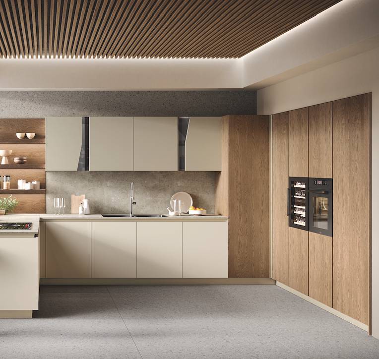 La cucina ad angolo con penisola Venere di Moretti Compact è in impiallacciato Rovere Tabacco e laccato Tortora Opaco. Il piano di lavoro è in laminato HPL – Rocks. Nell’angolo, la colonna lavanderia. www.cucine.moretticompact.it