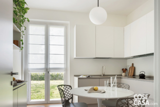 Cucina con tavolo rotondo, sedie e lampada sferica a sospensione Cucina con tavolo rotondo, sedie e lampada sferica a sospensione