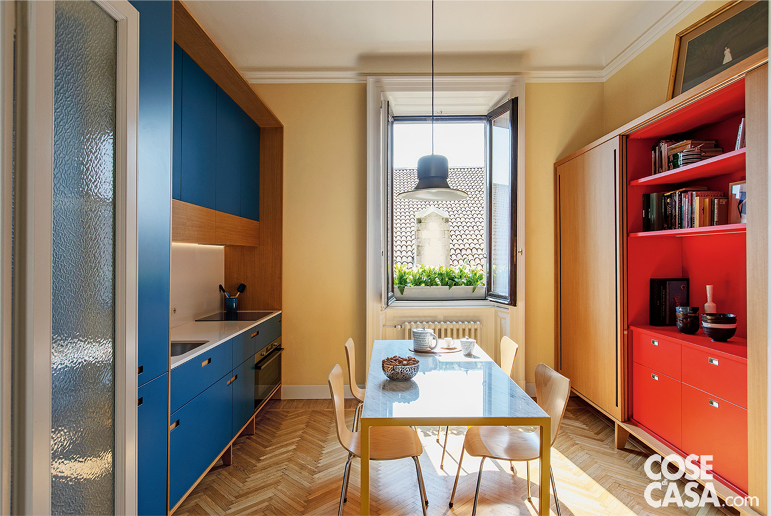 Cucina con tavolo, sedie e lampadario a sospensione Cucina con tavolo, sedie e lampadario a sospensione