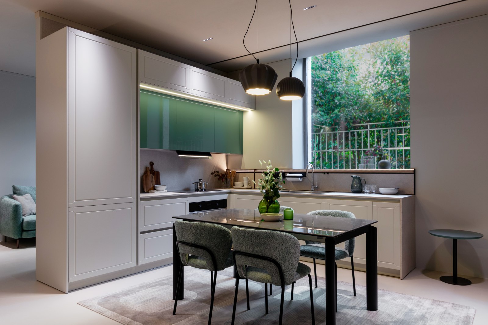 La cucina Myriad MI3 di Moretti Compact si sviluppa con una composizione ad angolo in melaminico Fango, abbinata ad ante laccate Grigio Seta opaco e Salvia lucido; il piano di lavoro con lavabo è in laminato HPL Stone Bianco. La struttura autoportante brevettata Panel, con montanti metallici che integrano il passaggio degli impianti, sostiene i pensili e consente di installare la cucina anche senza il supporto delle pareti. Al centro dell'ambiente trova posto un tavolo da pranzo di dimensioni 160 × 75 cm, ideale per condividere i pasti in compagnia. Prezzo base dell'anta battente L60 cm: 254 euro (gola, maniglia, zoccolo e top esclusi). Prezzo della composizione su richiesta. www.moretticompact.it