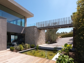 La passerella metallica sospesa ha un design leggero che collega la casa con parte del terreno. Pics Courtesy of Santoro Group srl La passerella metallica sospesa ha un design leggero che collega la casa con parte del terreno. Pics Courtesy of Santoro Group srl
