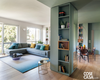 Zona living con divano angolare, tavolo e sedie