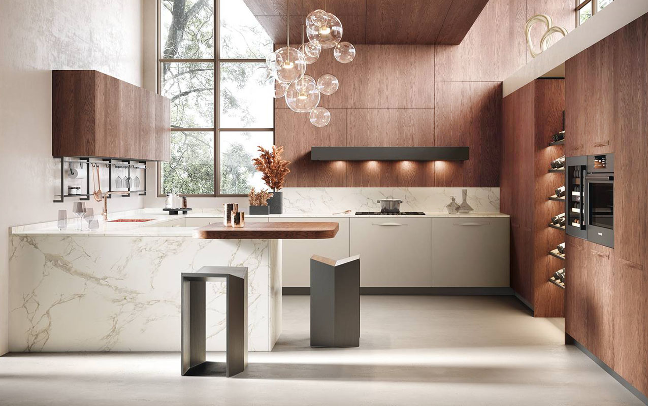 Moon 3 di Moretti Compact Cucine ha le basi con le ante lisce in Laccato Perla opaco e il piano di lavoro dell’isola in Laminam Fokos Roccia; il tavolo a sbalzo è in laminato HPL olmo mercurio. Tra le colonne, con le ante impiallacciate in Rovere Fiammato, trova posto una nicchia organizzata con un'ampia cantina per il vino. Un modulo base da 60 cm con anta a battente, prezzo 248 euro + Iva. https://www.moretticompact.it