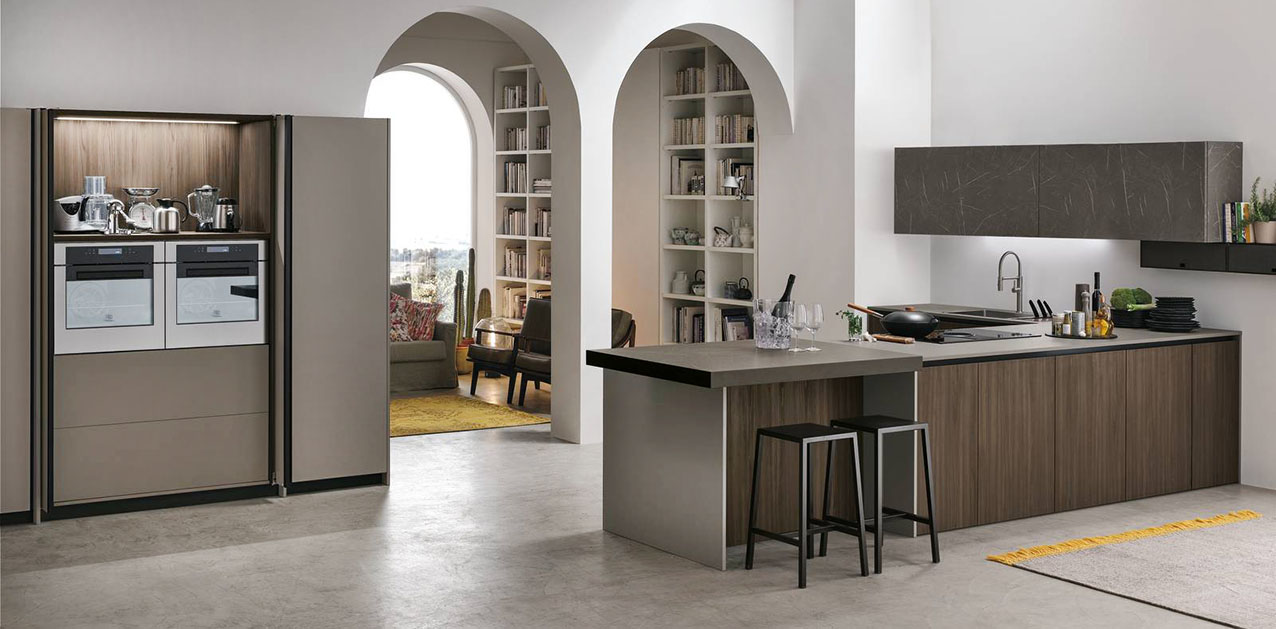 La cucina Metropolis di Stosa abbina un'isola centrale con il top scorrevole Slide, che permette di aumentare la superficie utile, alle colonne che racchiudono una nicchia con elettrodomestici grandi e piccoli. Le basi sono declinate nella finitura Larice Brown; le ante delle colonne sono realizzate in Pet Grigio Fumo opaco, quelle dei pensili nella texture materica del Grafte Brown. Prezzo su richiesta. https://www.stosacucine.com