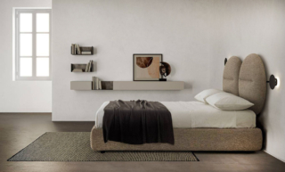 Una testata originale per il letto Bishape di Caccaro: è composta da due morbidi cuscini imbottiti rotondi, rivestiti in tessuto barnum, come il giroletto, e impreziositi da una cucitura centrale. È dotato di supporto luci con tecnologia touch che, grazie ai due bracci portalampade orientabili, permettono di leggere e può essere corredato di un vano contenitore. Misura L P160/180 x P 218/237 x H 127 cm. Prezzo a partire da 3.600 euro + Iva (per la versione base). https://www.caccaro.com