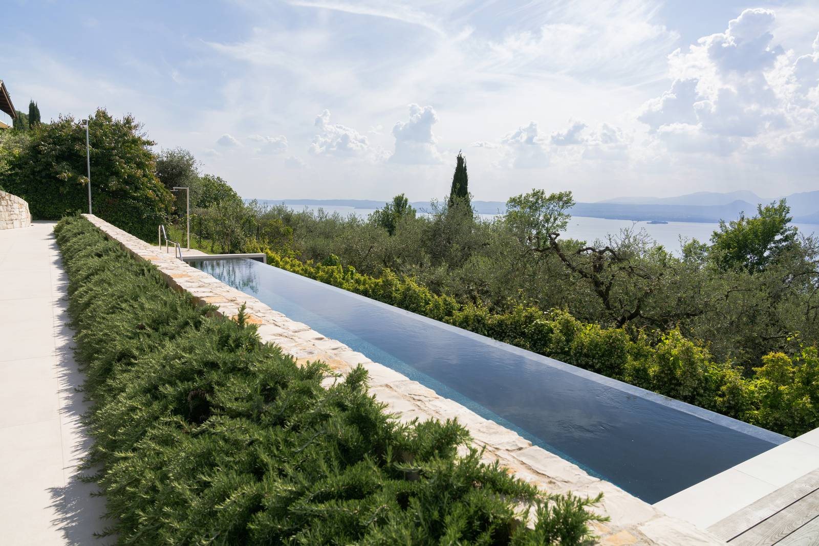 Piscina a sfioro firmata Piscine Castiglione per un'abitazione privata a Torri del Benaco (VR). Progetto arch. Marco Testi - Studio Spazio 42. Piscina a sfioro firmata Piscine Castiglione per un'abitazione privata a Torri del Benaco (VR). Progetto arch. Marco Testi - Studio Spazio 42.