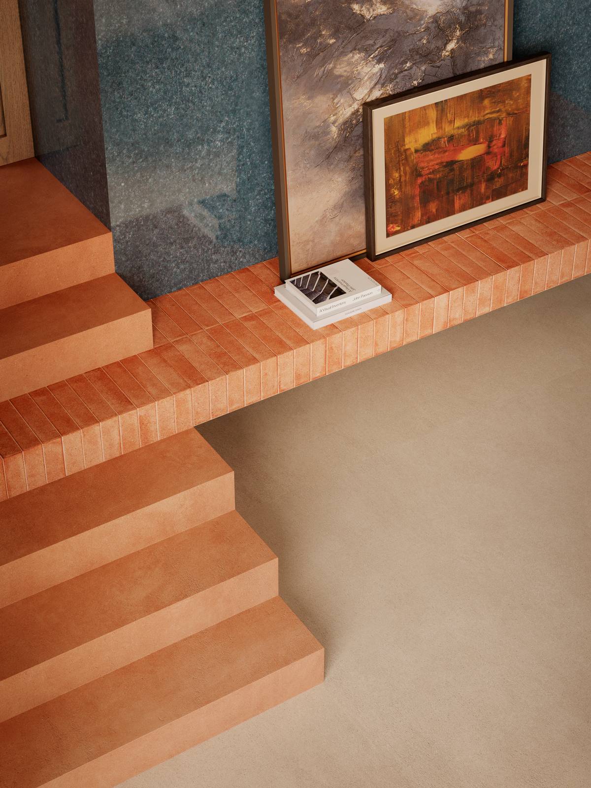 Dettaglio della parete rivestita con lastre ceramiche Grande Lume Cobalto nel formato 120x278 cm, la cui finitura lucida e profonda evoca la materia vetrosa artigianale. A pavimento trova spazio l’effetto materia di Grande Concrete Look Slow Calce 160x320 cm, mentre la scalinata è rivestita in Slow Cotto 120x120 cm. Completa la composizione la mensola con i piccoli formati Artcraft Cotto 5,3x30 cm, creando un sofisticato dialogo tra grandi superfici tecnologiche e suggestioni terrose. Dettaglio della parete rivestita con lastre ceramiche Grande Lume Cobalto nel formato 120x278 cm, la cui finitura lucida e profonda evoca la materia vetrosa artigianale. A pavimento trova spazio l’effetto materia di Grande Concrete Look Slow Calce 160x320 cm, mentre la scalinata è rivestita in Slow Cotto 120x120 cm. Completa la composizione la mensola con i piccoli formati Artcraft Cotto 5,3x30 cm, creando un sofisticato dialogo tra grandi superfici tecnologiche e suggestioni terrose.