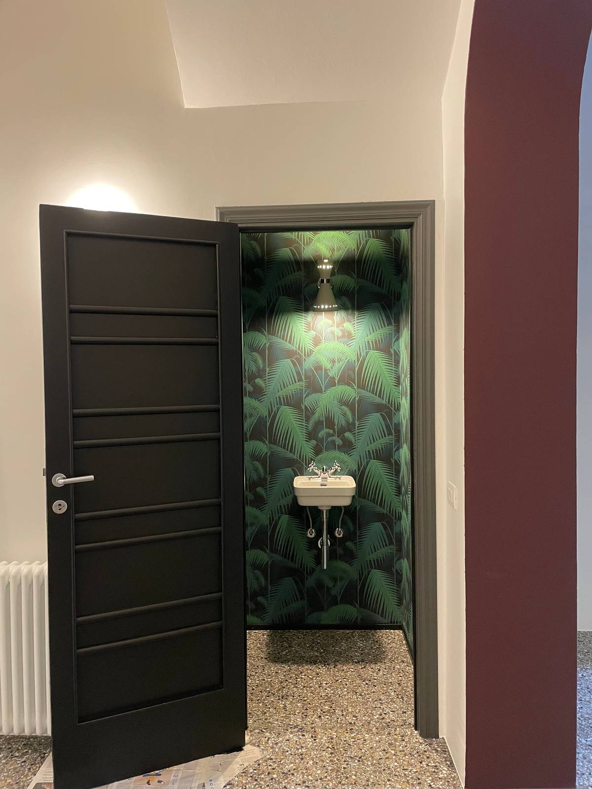 Ecco un mini bagno che punta su una carta a fondo nero con bambu verdi. Anche la porta è dipinta di nero sul lato interno, mentre le pareti esterne sono bianche e essenziali: il contrasto è assoluto, infatti quando si apre la porta l’effetto diventa ancora più sorprendente.