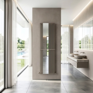 La nuova versione Mirror del radiatore Karin VX di Cordivari dal design minimal sarà presto disponibile sia nella versione verticale standard sia nella versione verticale Tandem, cioè con i corpi radianti disposti in doppia fila. L'integrazione di uno specchio arricchisce il radiatore di una nuova dimensione d'uso: in foto è installato in un ambiente bagno. Lo specchio può essere sistemato in posizione centrale oppure in configurazione decentrata. I collettori orizzontali sono in acciaio al carbonio verniciato ø 30 mm, mentre i corpi radianti verticali sono in acciaio al carbonio verniciato, di forma rettangolare e misurano 15 x 20 mm. Funziona ad acqua ed è disponibile in oltre 80 colori e in numerose dimensioni. www.cordivari.it – Cersaie 2026, Pad. 21, Stand A7/B6