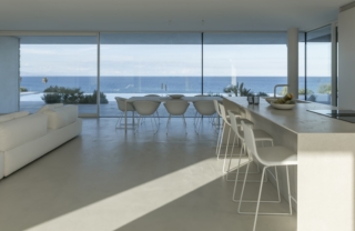 All'interno di Villa RMS gli spazi sono fluidi e continui, come la cucina nel living. I colori neutri e candidi amplificano la luminosità data dai serramenti Schüco. foto Sergio Pirrone