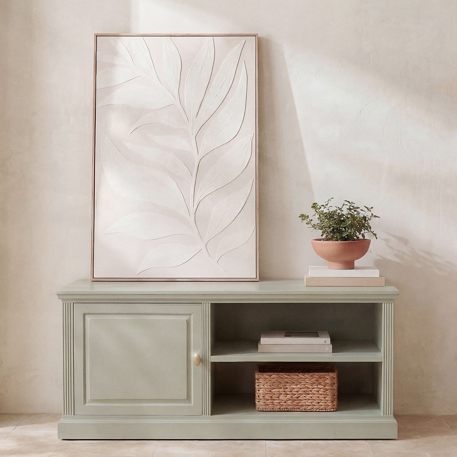 Il mobile TV Dalia di Maisons du Monde organizza lo spazio multimedia con una nota cromatica distintiva e design d'ispirazione classica. La silhouette equilibrata e la finitura verde-grigio definiscono l'area relax del soggiorno con eleganza sobria. Realizzato in pannelli di fibra a media densità con dettagli in legno di abete, dispone di ampi vani a giorno e uno scomparto chiuso. La maniglia in acciaio color ottone crea un contrasto luminoso, unendo estetica tradizionale e praticità moderna. Piano superiore 122 cm, altezza utile ripiani 20,5 cm. Prezzo 249,00 euro. www.maisonsdumonde.com